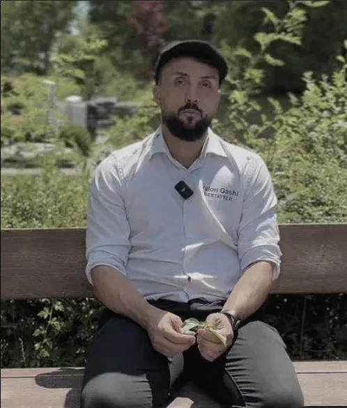 Valon Gashi auf einer Bank auf dem Friedhof